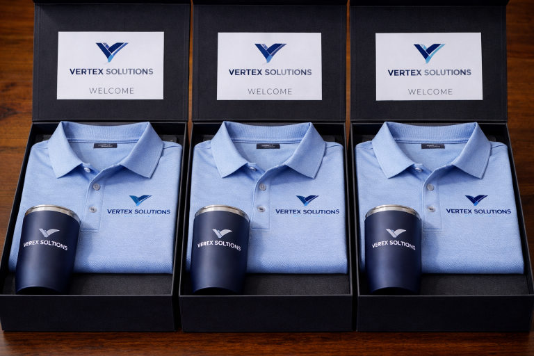 Identical VIP welcome kit boxes with Vertex Solutions branded polo shirt and stainless steel tumbler