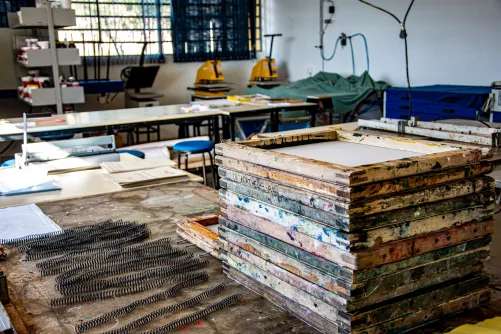 Interior of a textile workshop in Apucarana, highlighting screen printing frames and equipment.